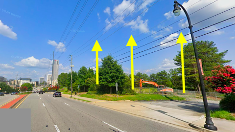 A large new development site with razed buildings in suburban Atlanta near two wide roads, under blue skies. 