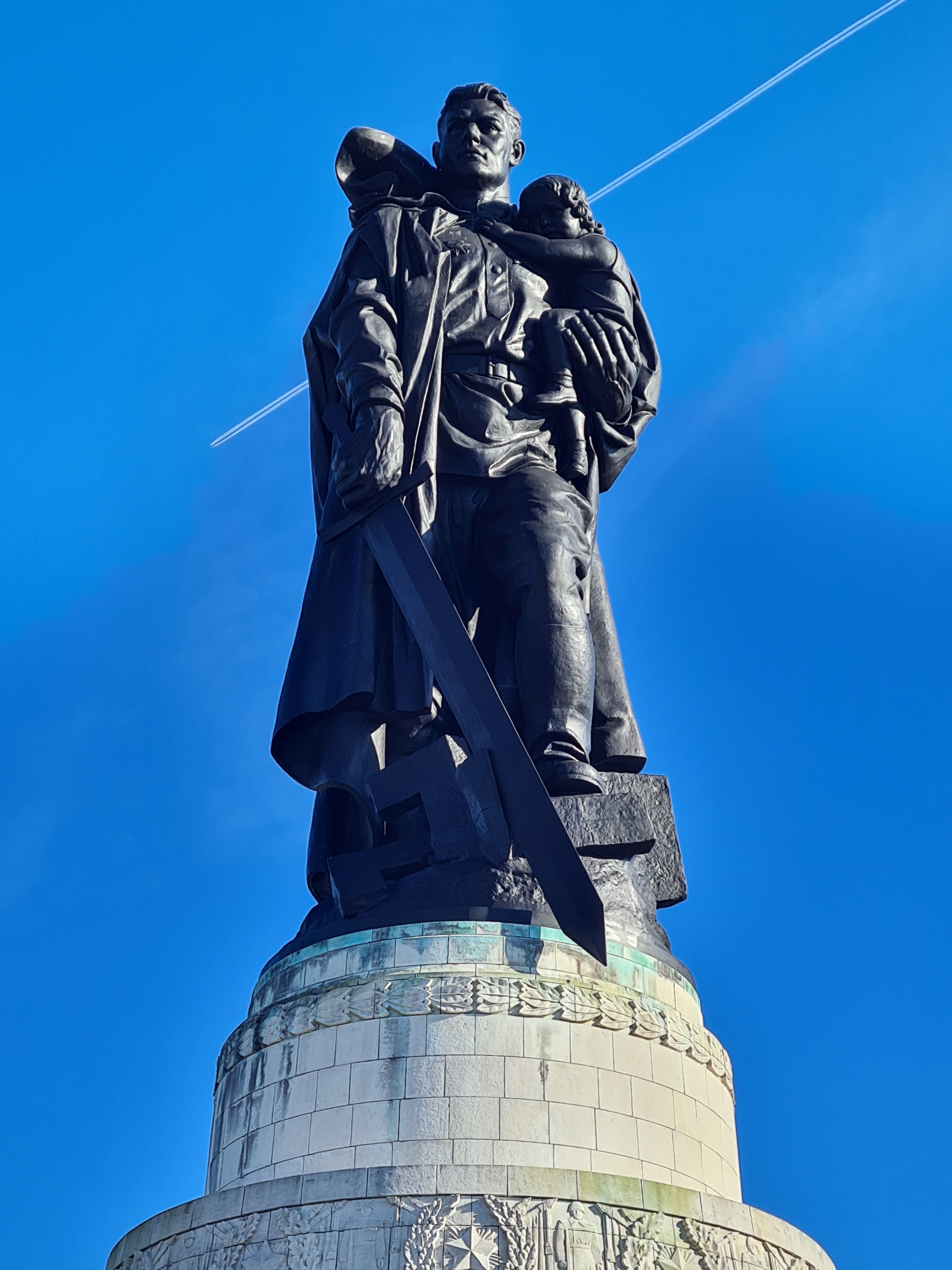 Escultura no parque Treptower Park, em Berlim, que representa um soldado soviético do exército vermelho carregando uma criança e pisando em uma suástica enquanto crava nesta uma espada.