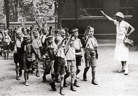 Eine gereihte Gruppe Grundschüler, die alle den Hitlergruß machen