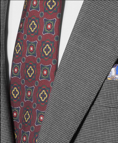 Closeup of a greyish suit with a "pied-de-poule" kinda pattern. And a tie that I wouldn't wear.