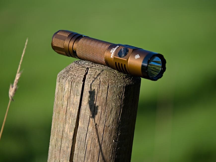 A brown Acebeam T35 flashlight sitting on a post