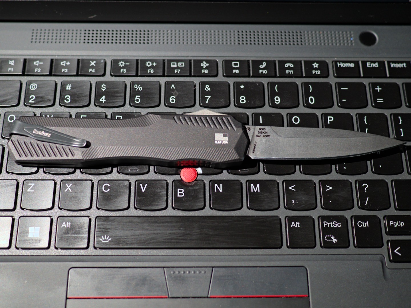 A Kershaw Livewire knife on a Thinkpad laptop keyboard