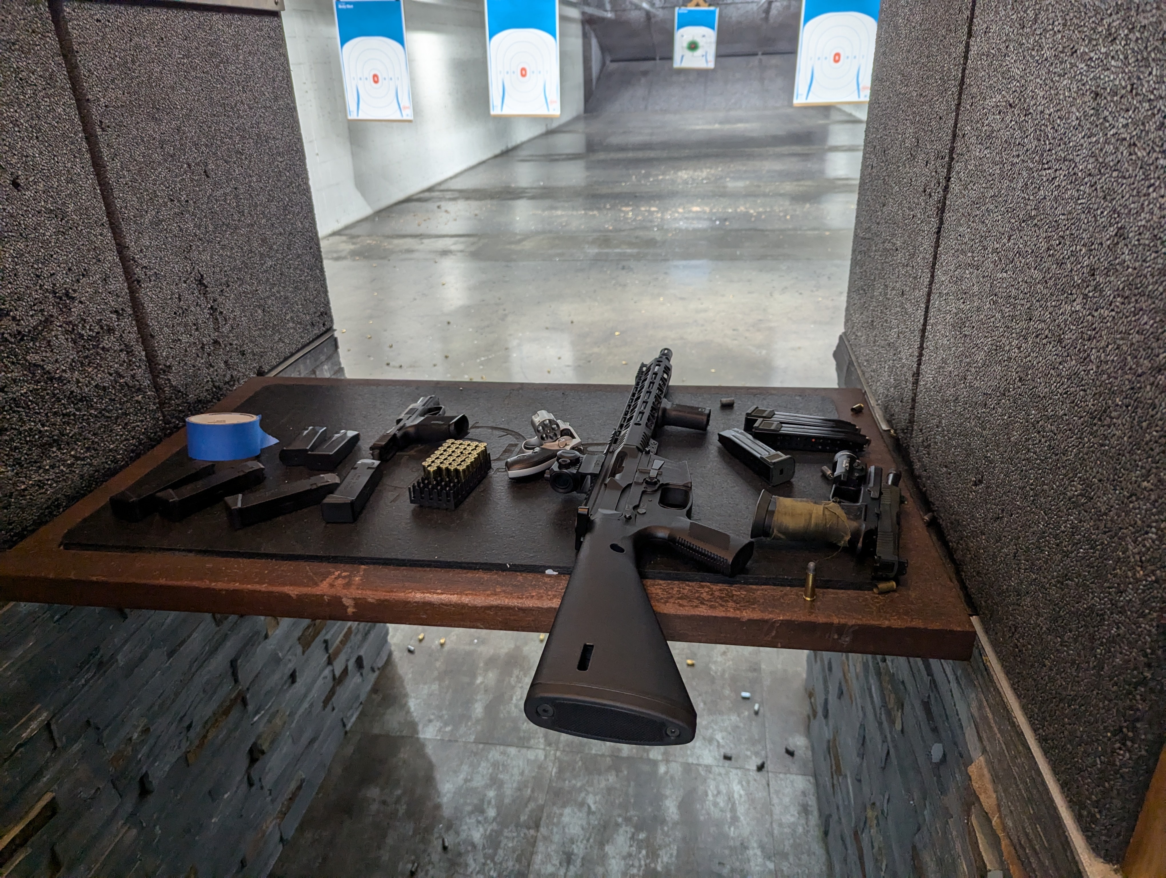 Pictured is a gun range stall with 3 handguns and 1 AR-9